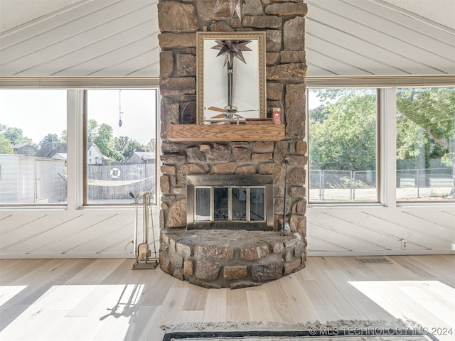 living room featuring wood walls, wood-type flooring, and a fireplace