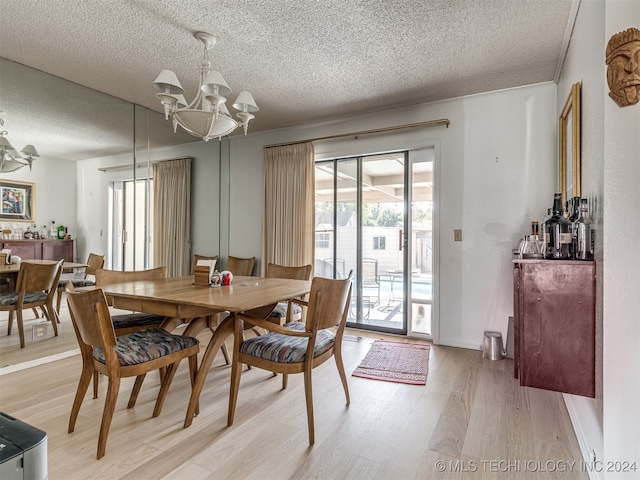 dining room featuring light hardwood / wood-style floors, a textured ceiling, and an inviting chandelier