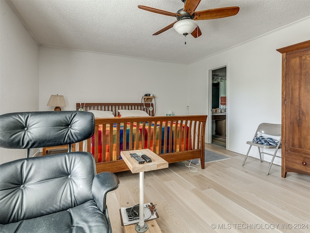 bedroom featuring light hardwood / wood-style flooring, ceiling fan, a textured ceiling, and ensuite bath