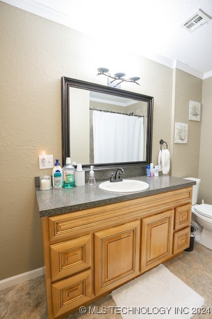 bathroom featuring vanity, toilet, and crown molding