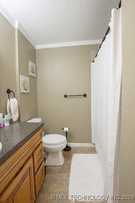 bathroom featuring vanity, toilet, ornamental molding, and a textured ceiling