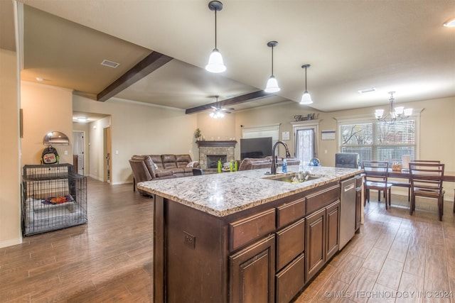 kitchen with a sink, baseboards, a fireplace, and wood finished floors