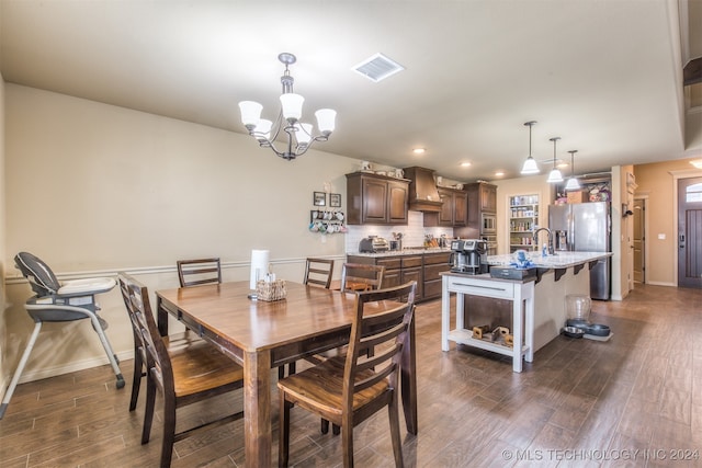 dining space with sink, a chandelier, and dark hardwood / wood-style floors