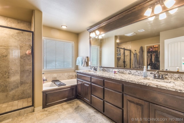 bathroom with a sink, double vanity, a stall shower, and a garden tub