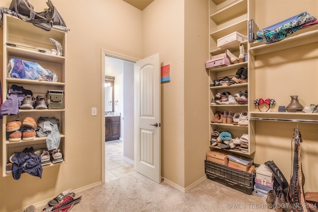 walk in closet featuring light carpet