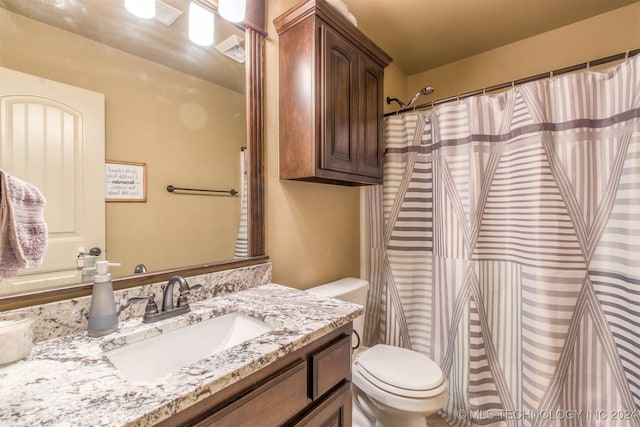 bathroom featuring vanity, curtained shower, visible vents, and toilet