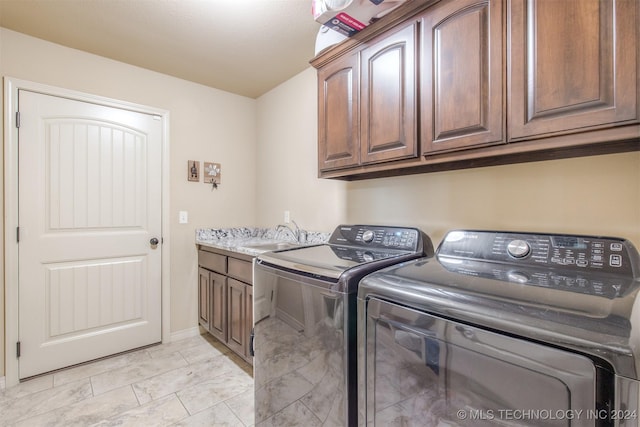 washroom with a sink, cabinet space, marble finish floor, and washing machine and clothes dryer