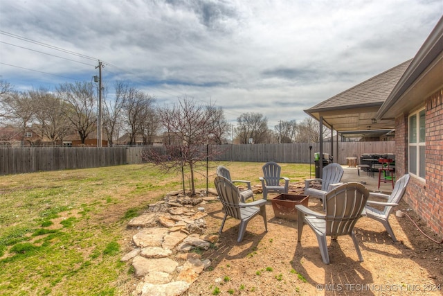 view of yard with a fenced backyard, an outdoor fire pit, and a patio area
