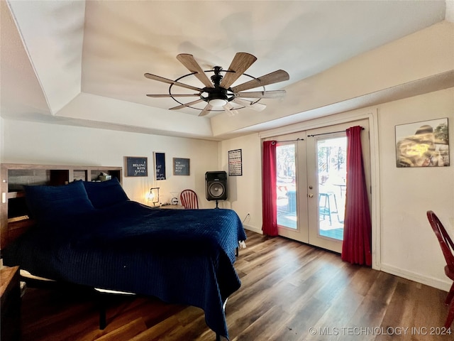 bedroom featuring access to outside, wood-type flooring, french doors, a raised ceiling, and ceiling fan