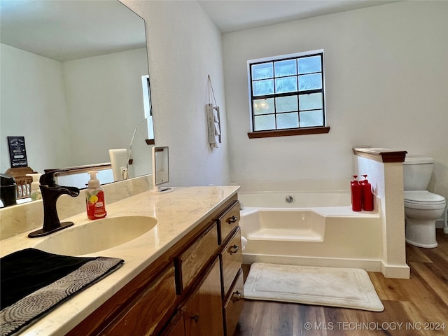 bathroom featuring vanity, wood-type flooring, toilet, and a bathing tub