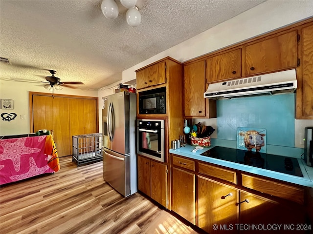 kitchen with light hardwood / wood-style floors, black appliances, a textured ceiling, and ceiling fan