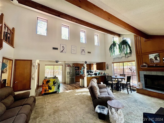 living room with light hardwood / wood-style flooring, a healthy amount of sunlight, and a high ceiling