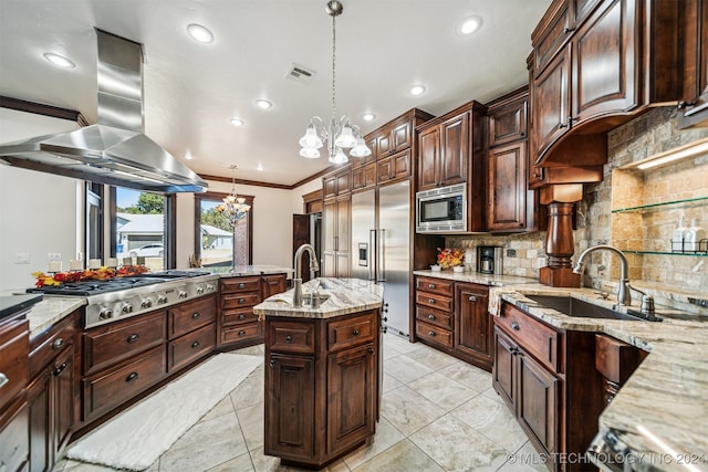 kitchen featuring an island with sink, island exhaust hood, decorative light fixtures, built in appliances, and an inviting chandelier