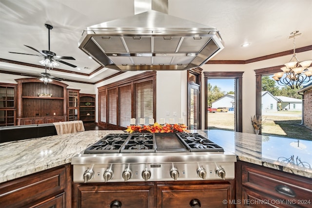 kitchen featuring island range hood, ornamental molding, light stone countertops, decorative light fixtures, and stainless steel gas stovetop