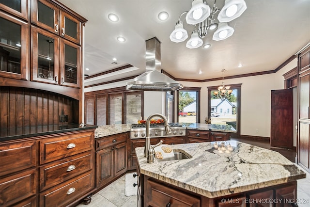 kitchen featuring a center island with sink, island exhaust hood, light stone countertops, and an inviting chandelier