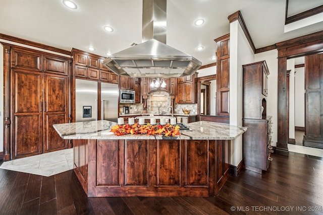 kitchen featuring a spacious island, dark hardwood / wood-style flooring, built in appliances, and island range hood