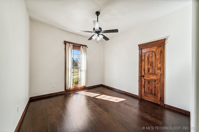 unfurnished room featuring dark wood-type flooring and ceiling fan