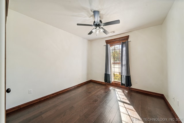 unfurnished room featuring dark wood-type flooring and ceiling fan