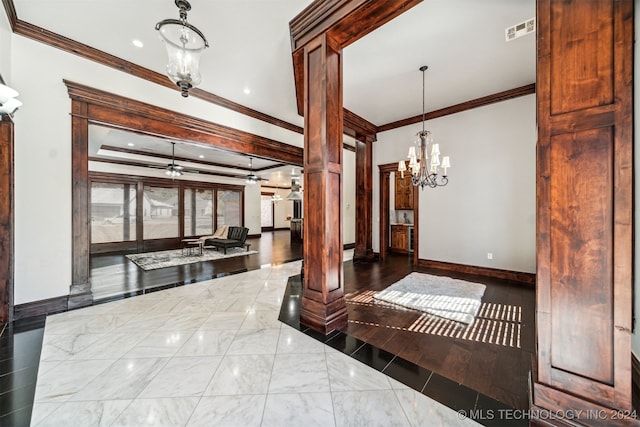 interior space with wood-type flooring, decorative columns, an inviting chandelier, and ornamental molding