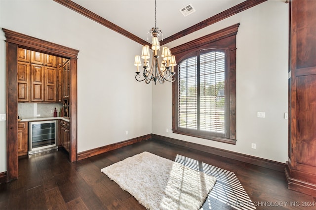 unfurnished dining area with wine cooler, ornamental molding, dark wood-type flooring, and an inviting chandelier