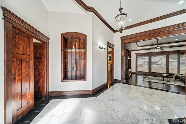 foyer with ornamental molding and ceiling fan