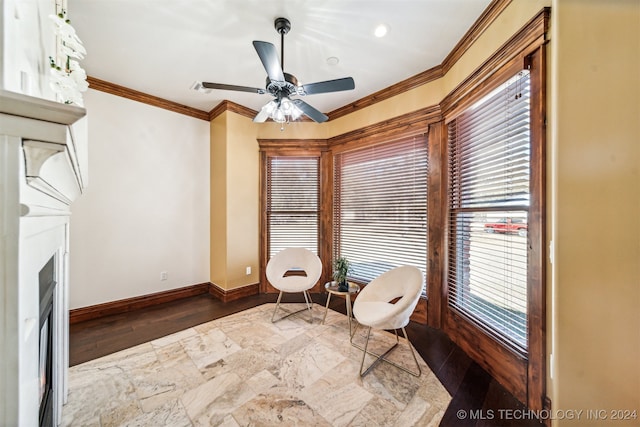 living area with dark hardwood / wood-style flooring, crown molding, and ceiling fan