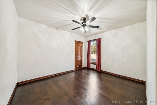 spare room featuring dark wood-type flooring and ceiling fan