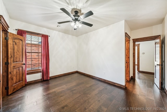 empty room featuring dark wood-type flooring and ceiling fan