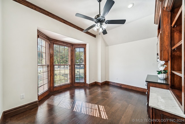 spare room featuring ceiling fan, ornamental molding, dark hardwood / wood-style flooring, and vaulted ceiling