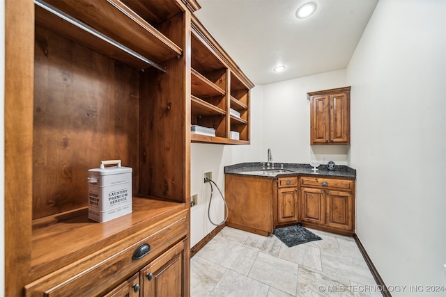 interior space with cabinets, hookup for a washing machine, and sink