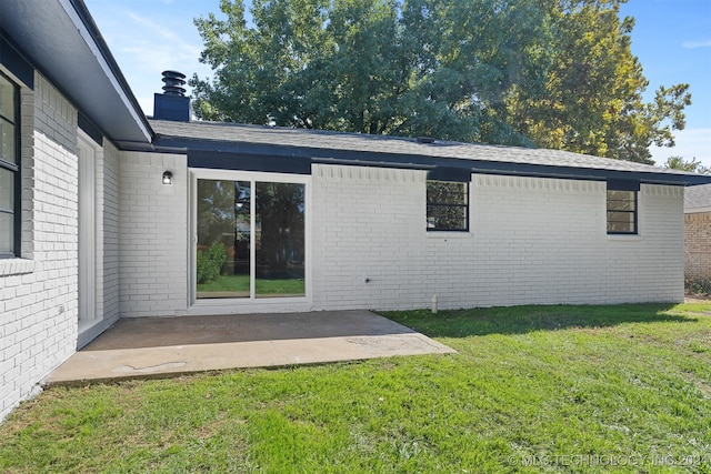 rear view of house with a patio and a lawn