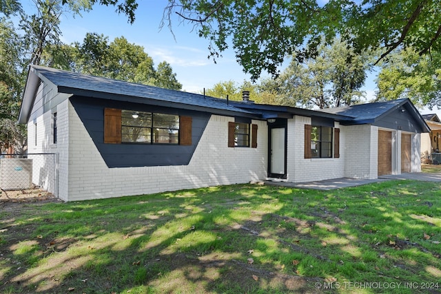 ranch-style house featuring a front yard and a garage