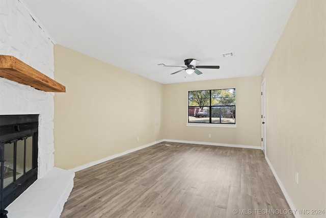 unfurnished living room with hardwood / wood-style floors, a fireplace, and ceiling fan