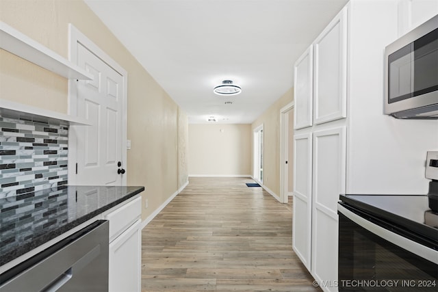 kitchen with white electric range, decorative backsplash, and white cabinets