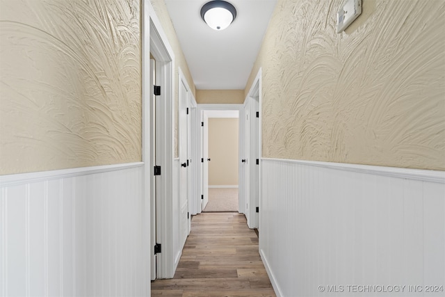 hallway featuring wood walls and hardwood / wood-style floors