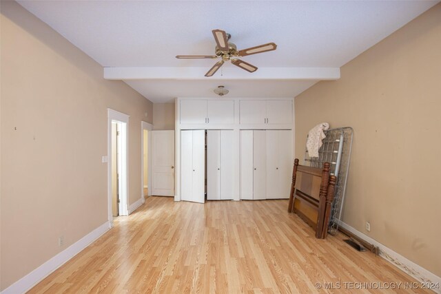921 D NW, Ardmore, OK 73401 - unfurnished bedroom featuring beam ceiling, light wood-style flooring, and multiple closets