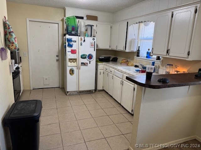 kitchen with kitchen peninsula, white cabinets, a textured ceiling, sink, and white refrigerator with ice dispenser