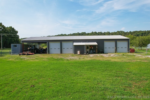 garage with a carport and a lawn