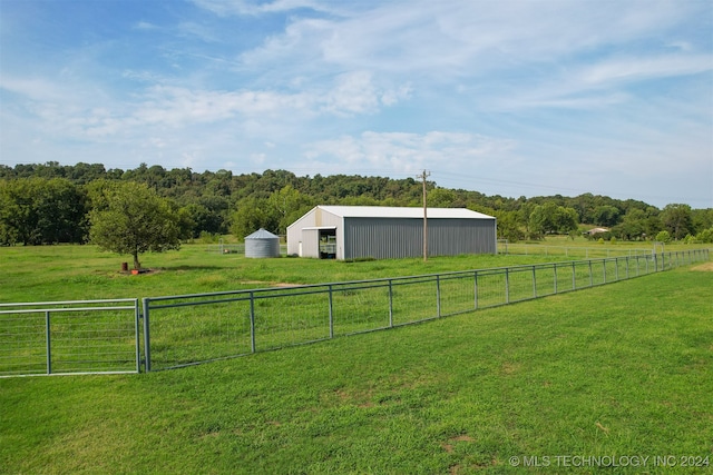 view of yard with an outdoor structure and a rural view