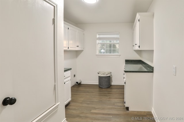 laundry area with hookup for an electric dryer, dark wood-type flooring, and cabinets