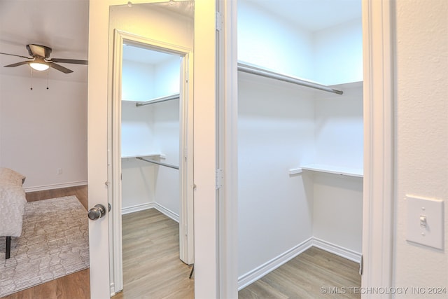 walk in closet with light hardwood / wood-style floors and ceiling fan