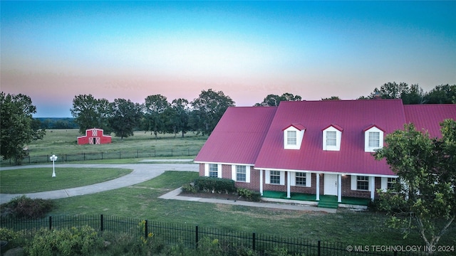 view of front of property featuring a yard and a storage shed