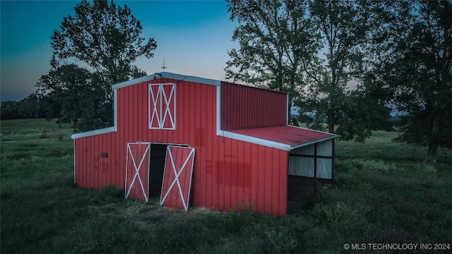 outdoor structure at dusk featuring a yard