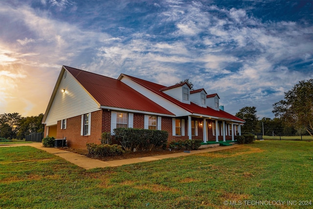 property exterior at dusk with central AC and a yard