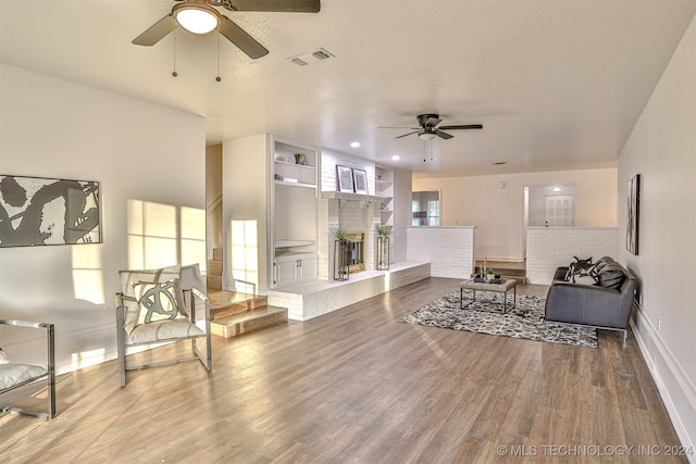 living room featuring ceiling fan and hardwood / wood-style flooring