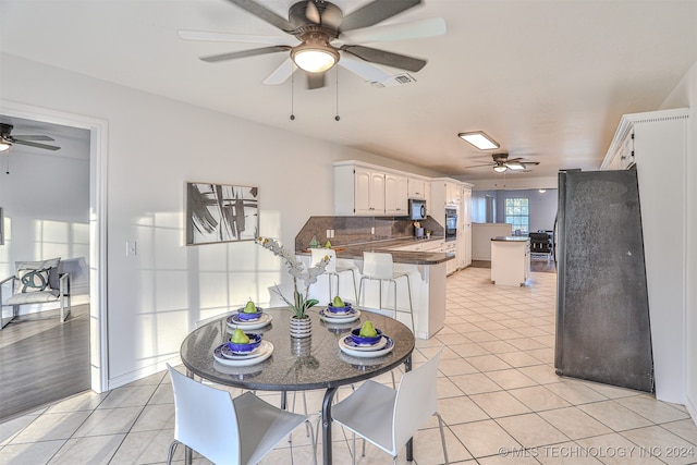 kitchen featuring black appliances, white cabinetry, kitchen peninsula, and backsplash