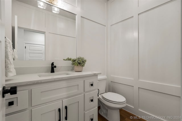 bathroom with vanity, hardwood / wood-style flooring, and toilet