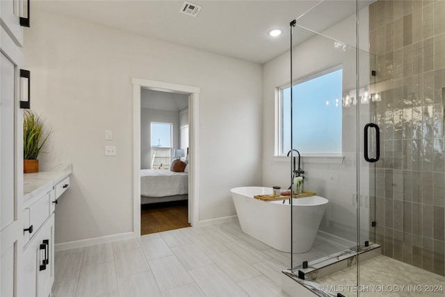 bathroom featuring vanity, independent shower and bath, and tile patterned flooring