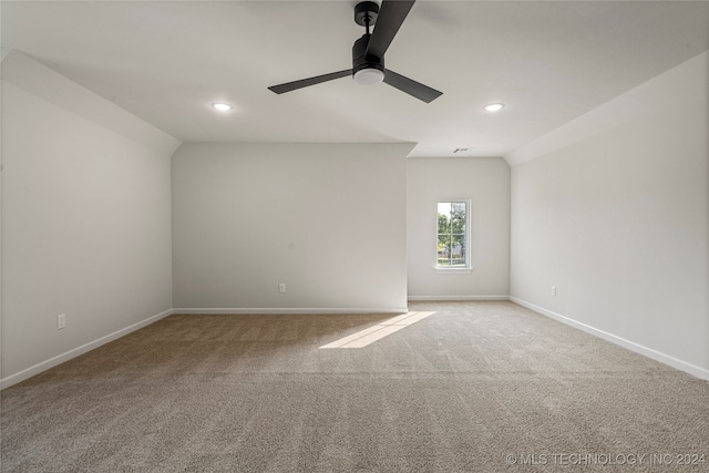 empty room featuring ceiling fan, light carpet, and lofted ceiling