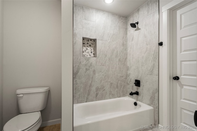 bathroom with toilet and tiled shower / bath combo